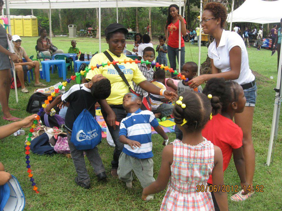 These boys and a Food For The Poor volunteer do the limbo under a arch they made from pegs in the pegboard set in the Crayons Count learning kit.